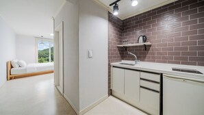 Una cocina moderna con salpicadero de ladrillo, lavavajillas integrado y ventana con vistas a un paisaje verde.