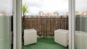 A balcony with a view of buildings, a bamboo fence, and two white chairs. - De Angeli 60-square-meter apartment - M1 & M4 - near CityLife, Tortona district, San Siro (Milano)