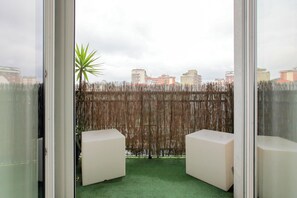 A balcony with a view of buildings, a bamboo fence, and two white chairs. - De Angeli 60-square-meter apartment - M1 & M4 - near CityLife, Tortona district, San Siro (Milano)