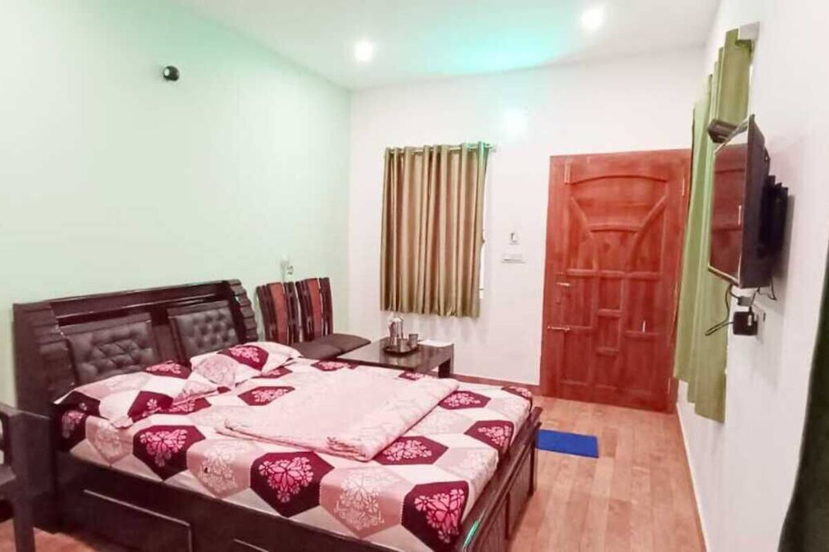 Une chambre à coucher comprenant un lit, un bureau, une chaise, une télévision et une armoire.