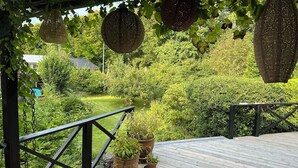 A wooden deck with potted plants, a metal railing, and hanging baskets. - Fully modernized in 2026, 1 minut from the ocean (Børkop)