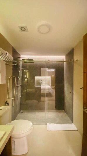 Une salle de bain moderne avec une douche à parois de verre, des toilettes et un lavabo.