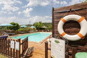 A pool area with wooden deck, lounge chairs, and umbrellas. - Majestic Villa Retreat (Assisi)