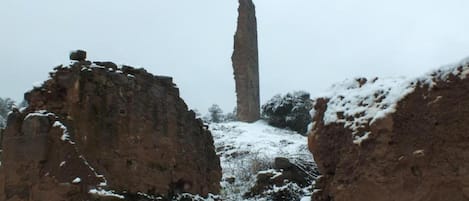 Eine felsige Landschaft mit einer hohen, schlanken Steinarchitektur in der Ferne.