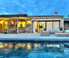 A modern house with a stone facade, a pool, outdoor furniture, and a pergola. - Villa 8 persons Heated swimming pool. Petanque court Electric car terminal (Porto-Vecchio)
