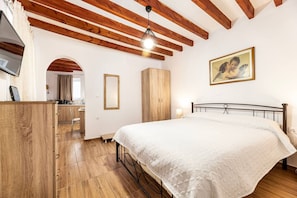 Une chambre à coucher avec un lit, une armoire en bois et un tableau accroché au mur.