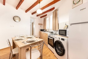 Une cuisine compacte équipée d’un lave-linge, d’un four à micro-ondes et d’une cuisinière.