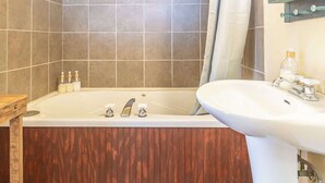 Un bagno con una vasca, un lavandino e una tenda da doccia.