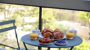 Une table avec des croissants, des fraises, des myrtilles et des verres de jus d’orange.