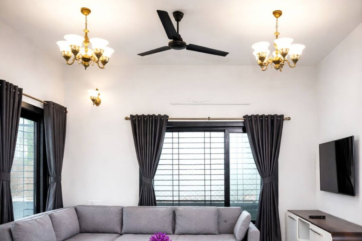 Una sala de estar moderna con un sofá modular, una mesa de centro, un televisor y un ventilador de techo.
