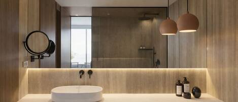 A modern bathroom with a round sink, two pendant lights, a mirror, and a towel rack.