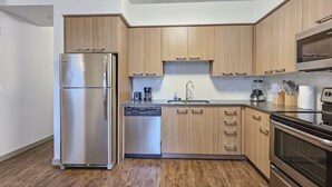 Une cuisine moderne avec des meubles en bois, des appareils électroménagers en acier inoxydable et un lave-vaisselle.