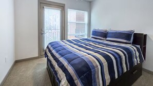 Une chambre à coucher avec un lit, un ventilateur de plafond et une fenêtre avec des stores.