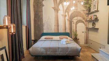 A bedroom with a bed, a nightstand, a potted plant, and a staircase.