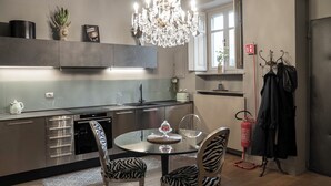 A modern kitchen with a chandelier, a dining table with zebra-patterned chairs, and a fire extinguisher. - Elegant apartment in the heart of Vigevano, a stone's throw from Piazza Ducale (Vigevano)