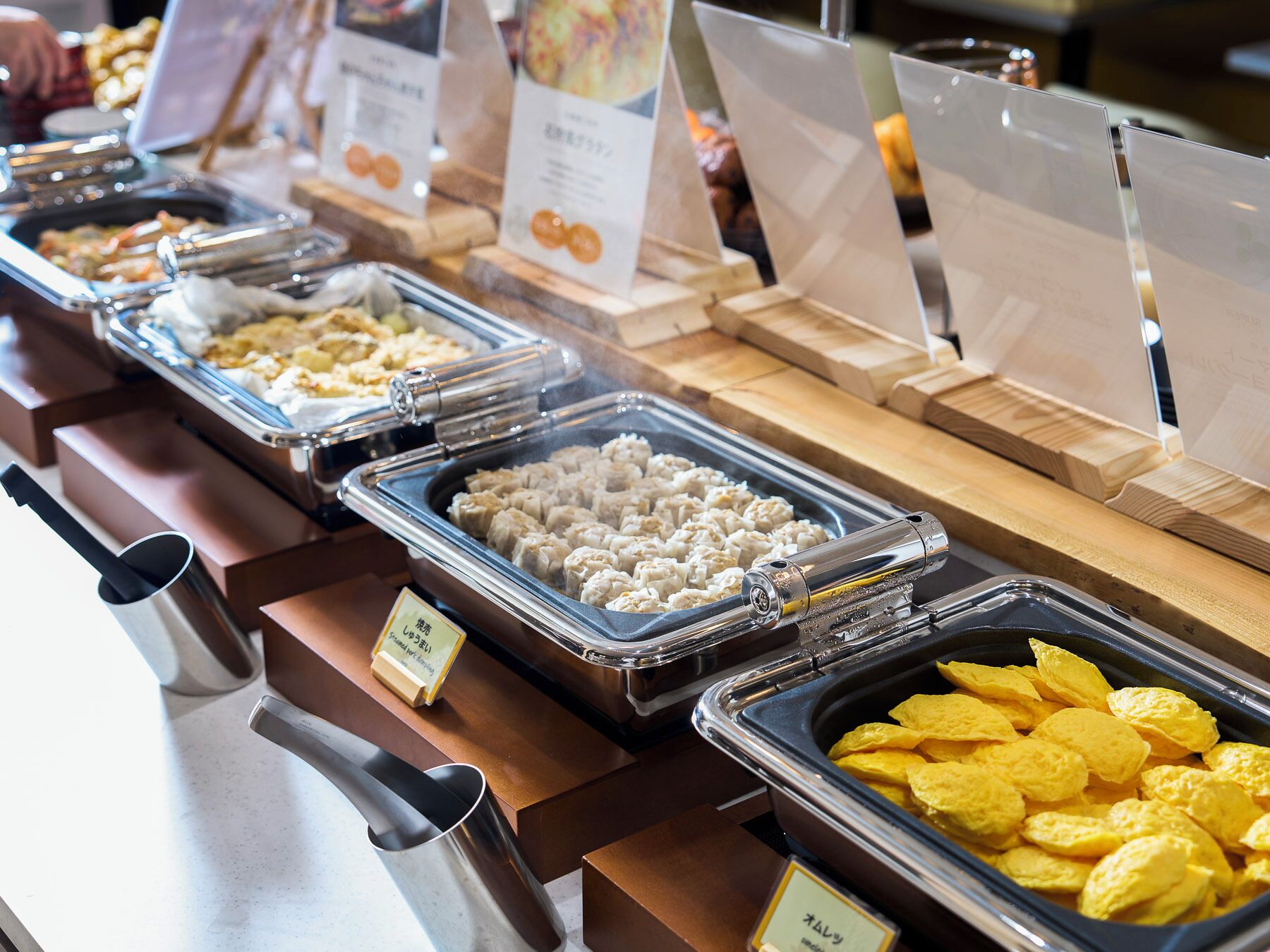 A buffet with various food items including dumplings, a salad, and chips.