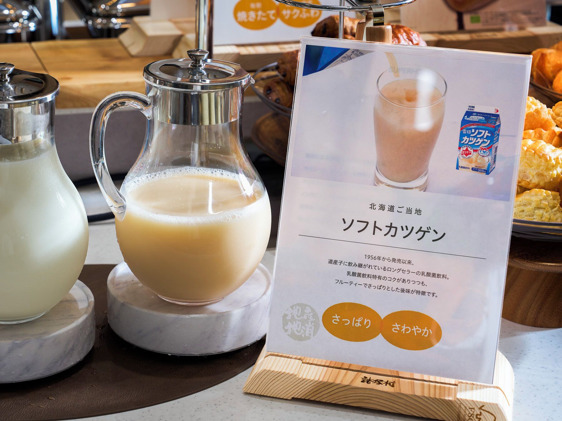 Un stand de boissons avec une carafe et un verre, ainsi qu’un menu rédigé en japonais.