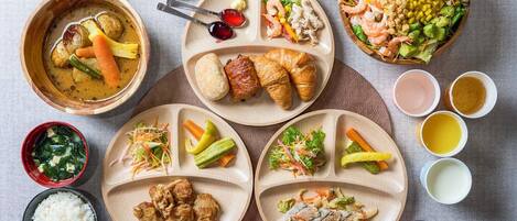 A variety of dishes including soup, rice, and salads, arranged on multiple plates and bowls.