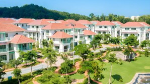 A resort with multiple white buildings, red roofs, and lush greenery. - Ocha Villa (Phu Quoc)