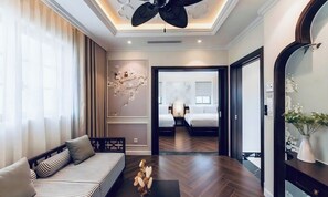 A modern hotel room with a sofa, a small table, and a decorative wall piece. - Ocha Villa (Phu Quoc)