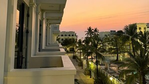 A hotel with a modern architectural design, featuring balconies, a pool area, and palm trees. - Ocha Villa (Phu Quoc)
