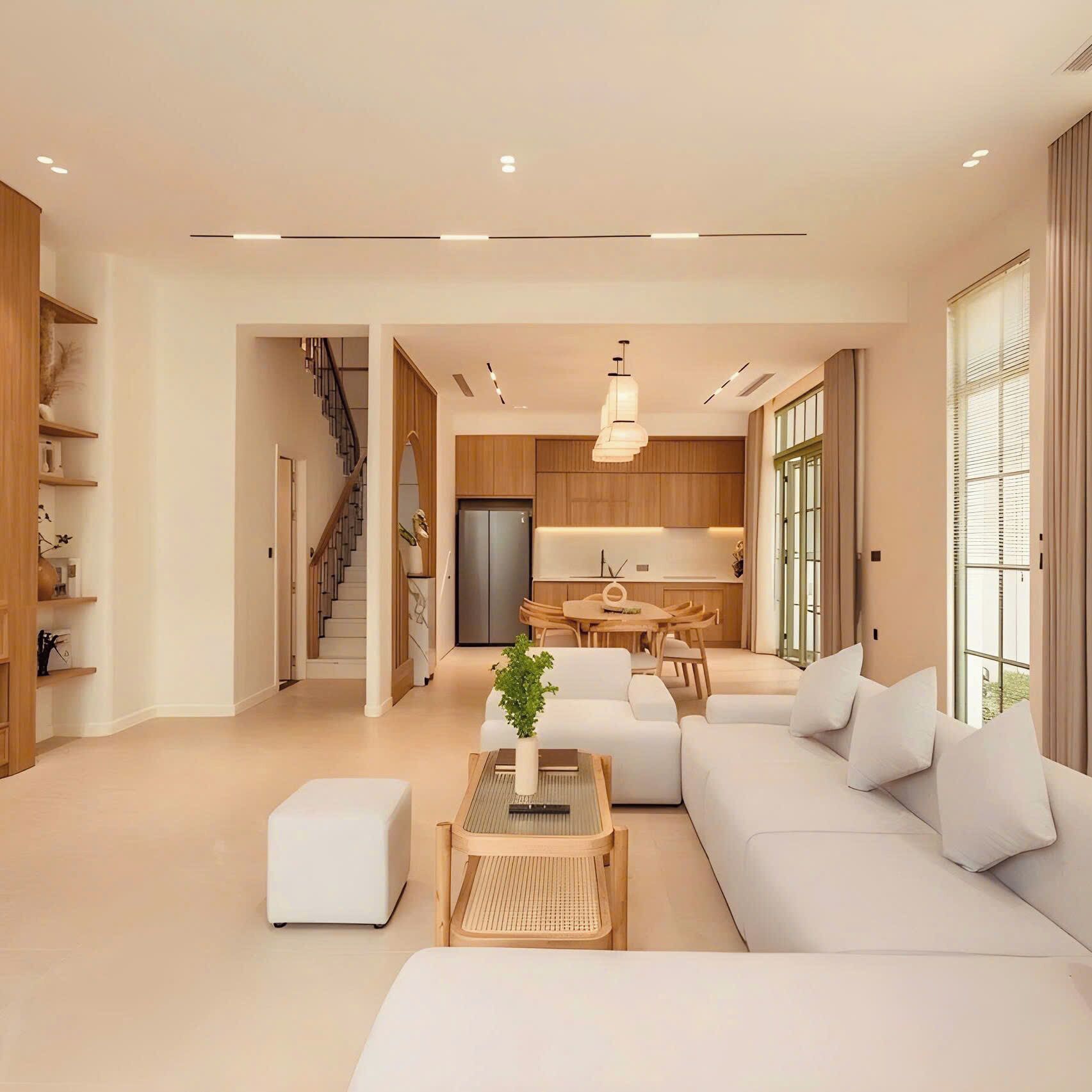 A modern living room with a sofa, coffee table, and a dining area with a table and chairs.