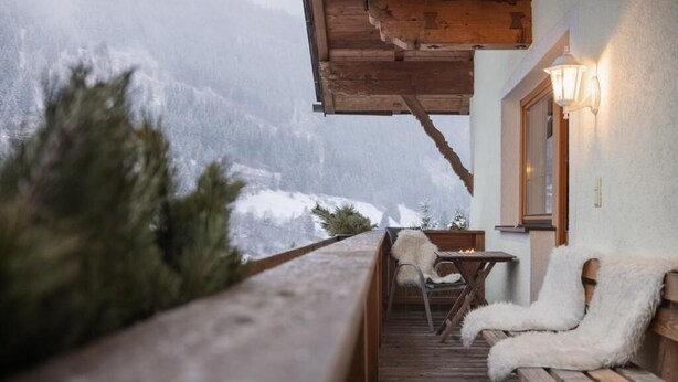 A wooden deck with a bench and a table, overlooking a snowy mountain landscape. - Haus Alpenkönig  (Neustift Im Stubaital)