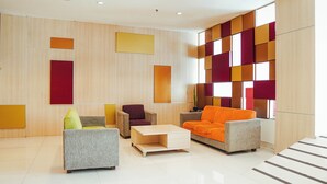A modern lobby with a seating area, a coffee table, and a large window with a view. - The Himana Hotel Malang (Malang)