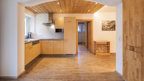 Een moderne keuken met houten kastjes, een magnetron en een inbouwoven.