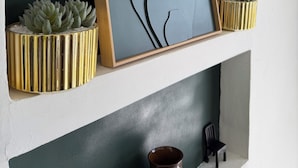 A framed artwork on a shelf, two potted plants, and a vase. - La Kaz by Kaz Kafe (Pamandzi)
