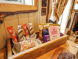 A wooden tray with snacks, a bottle of champagne, and a sign for Twit Twoo.