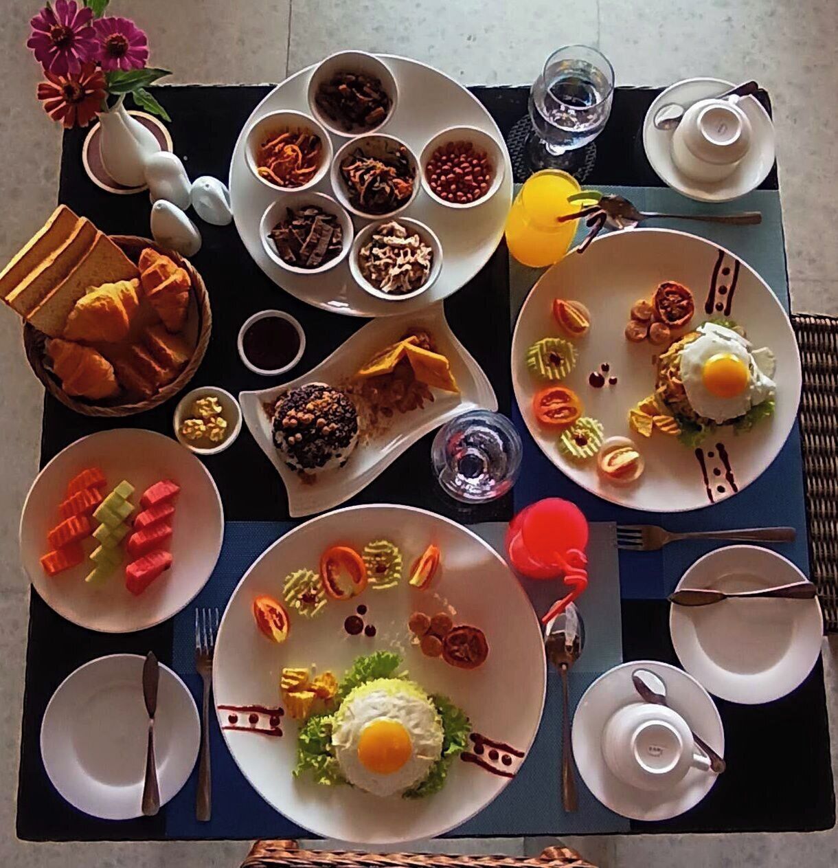 En frukostbuffé med olika rätter och serveringsredskap uppdukad på ett bord.