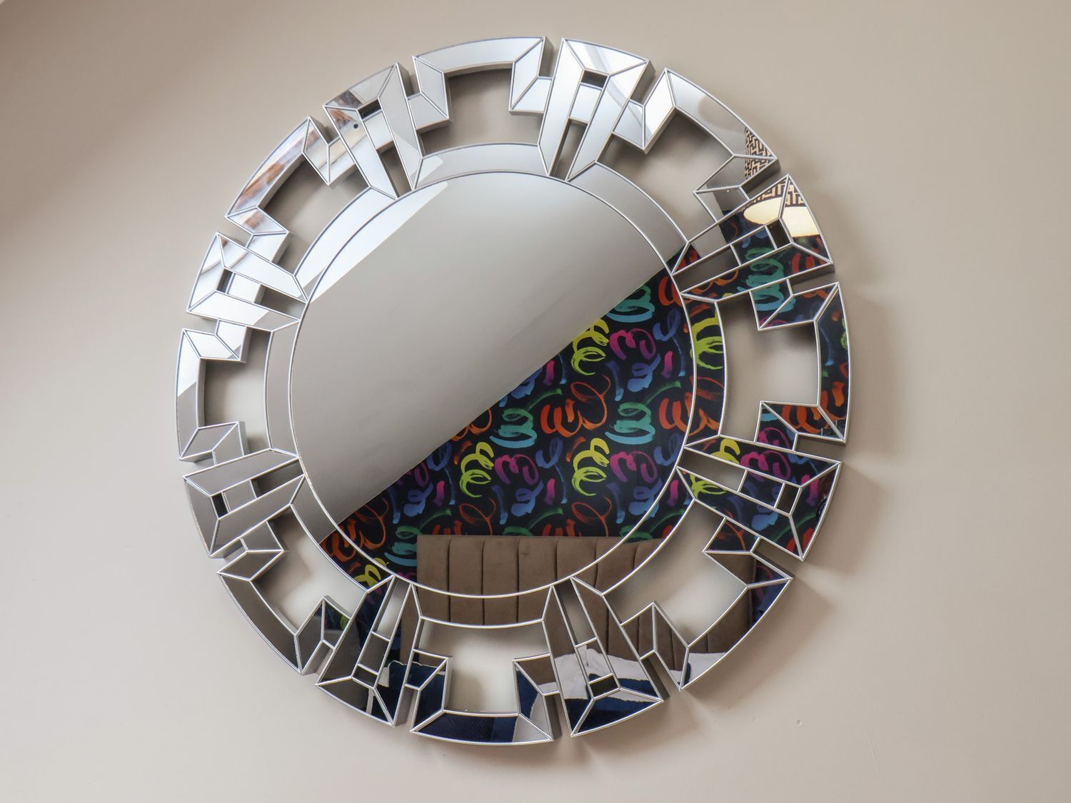Una pieza de arte mural metálica circular con recortes geométricos.