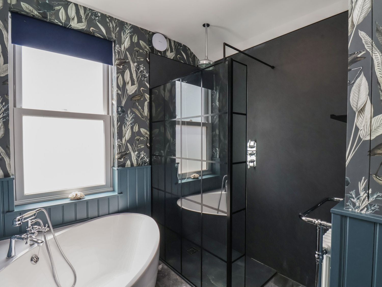 A modern bathroom with a freestanding bathtub, a glass-enclosed shower, and a window with a view.