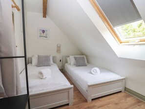 A small, modern room with two beds, a skylight, and a simple, clean design. - Redwoods (Beverley)
