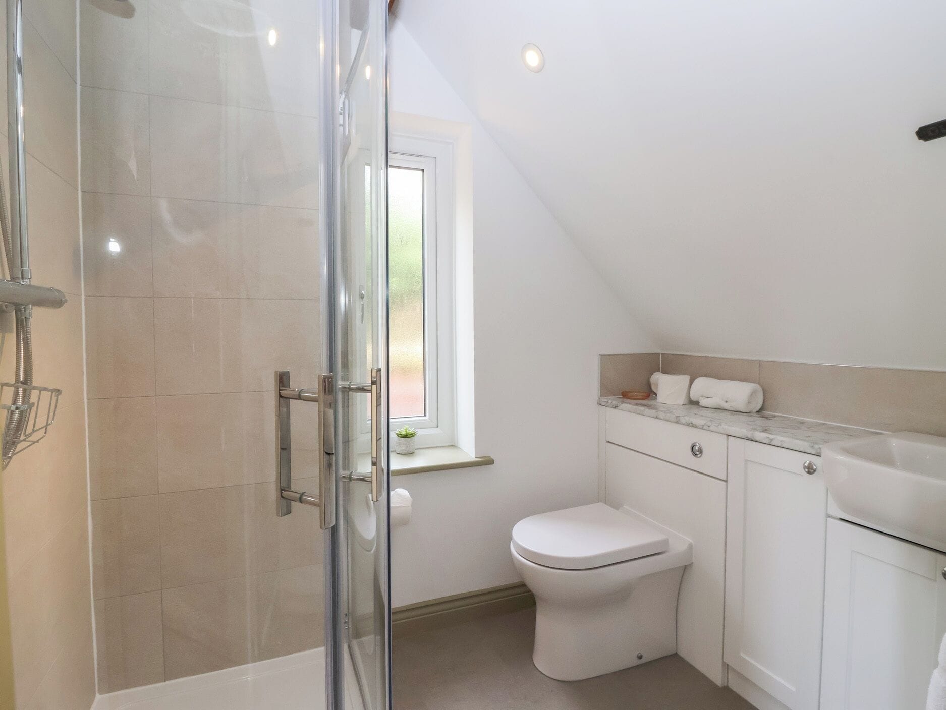 Ein modernes Badezimmer mit Duschkabine, Toilette und Waschbecken.