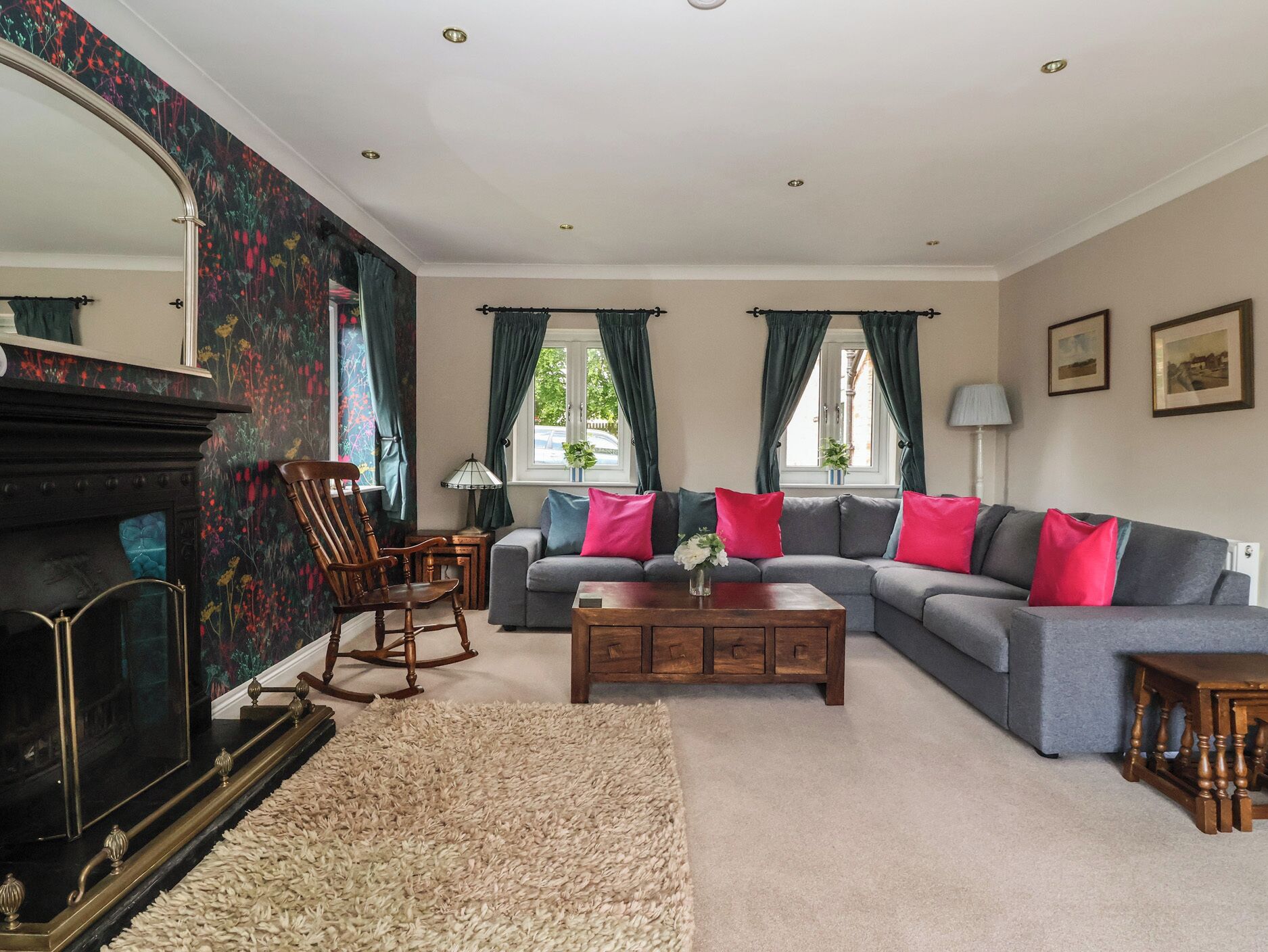 A living room with a fireplace, a sofa set, a rocking chair, and a coffee table.