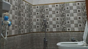 Een badkamer met toilet, douche en wastafel.