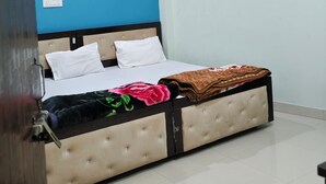 Een slaapkamer met een bed, een plafondventilator en een blauwe accentmuur.