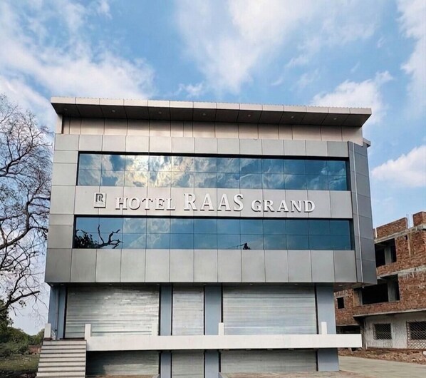 Un edificio moderno con il cartello 'HOTEL RAAS GRAND' che indica un albergo.