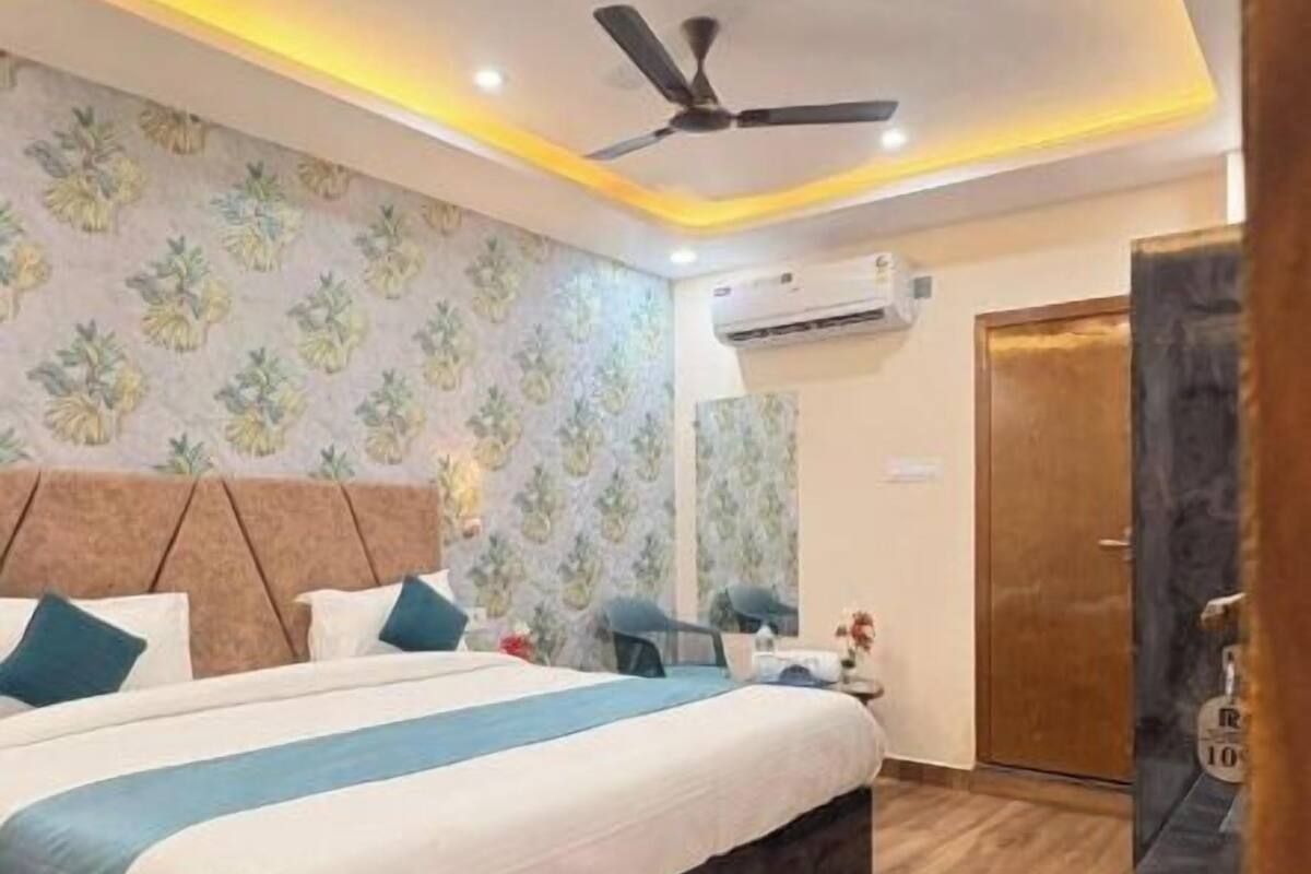 A bedroom with a bed, ceiling fan, and wooden flooring.