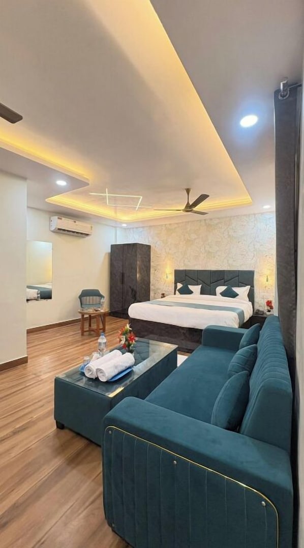 Una habitación de hotel moderna con una cama, un sofá y una pequeña mesa con toallas.