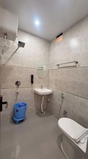Un baño con inodoro, lavamanos y ducha.