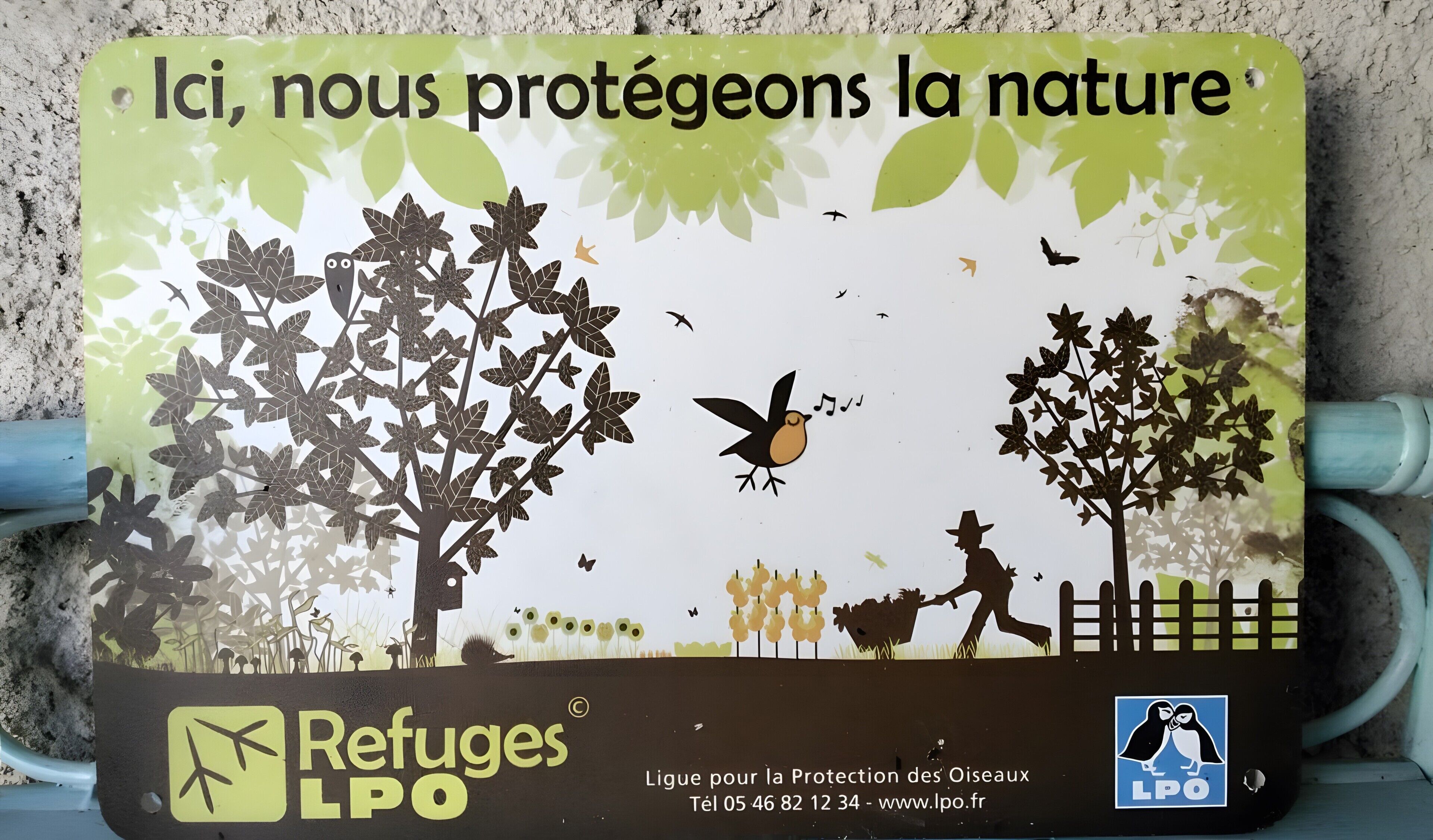 A sign with nature protection message and contact information for Refugees LPO.