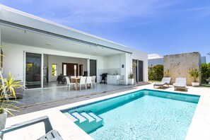 A modern house with a swimming pool, outdoor seating, and a patio area. - Family Villa with Private Pool in Sosua Ocean Village (Sosúa)