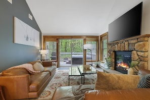 A cozy living room with a stone fireplace, leather sofa, and a flat-screen TV. - Summer fun at camelback • Hot Tub & Pool (Jackson Township)