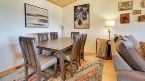 Un coin repas avec une table et des chaises en bois, un canapé et une lampe.