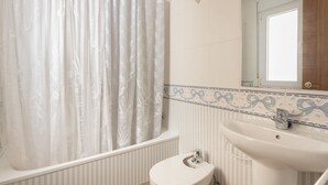 A bathroom with a bathtub, toilet, and sink. - Puerto Bahía House . (Tarifa)
