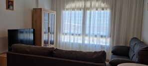 Ein Wohnzimmer mit einer Couch, einem Schrank und einem Fernseher.