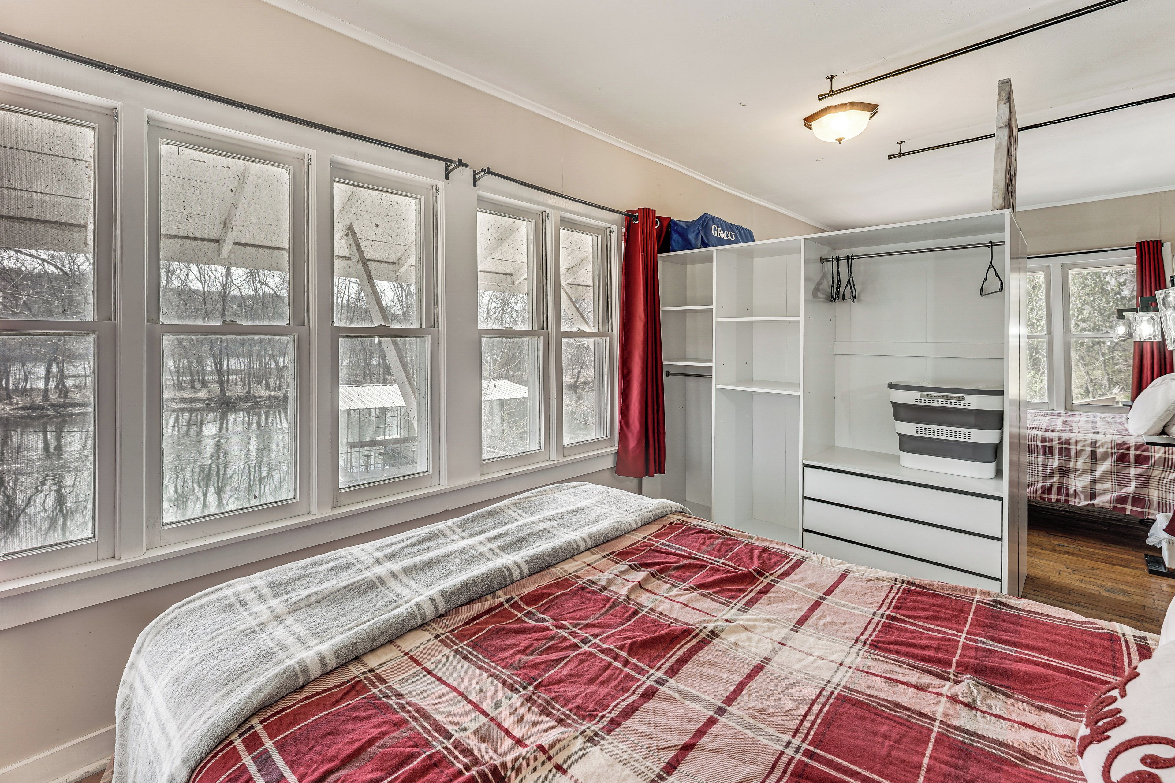 Un dormitorio con cama, ventana con vista a un paisaje nevado, armario y espejo.